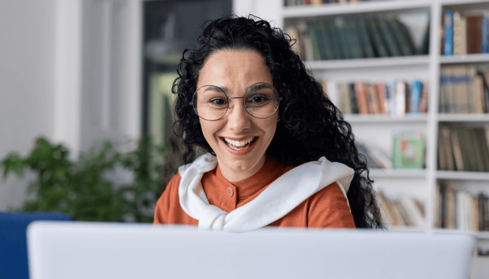 Femme qui sourit devant son ecran d ordinateur